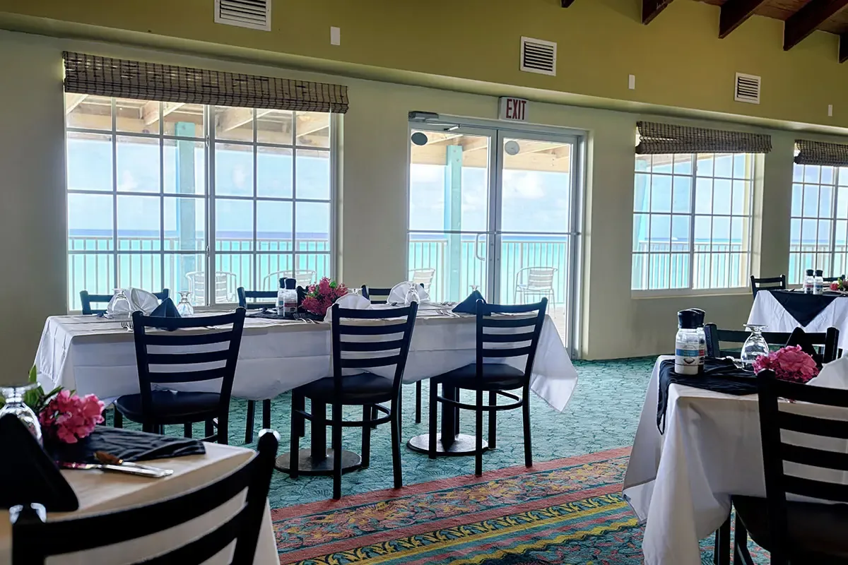 Espacio representativo del hotel: Un salón de banquetes con mesas junto a grandes ventanales que dan a un balcón.