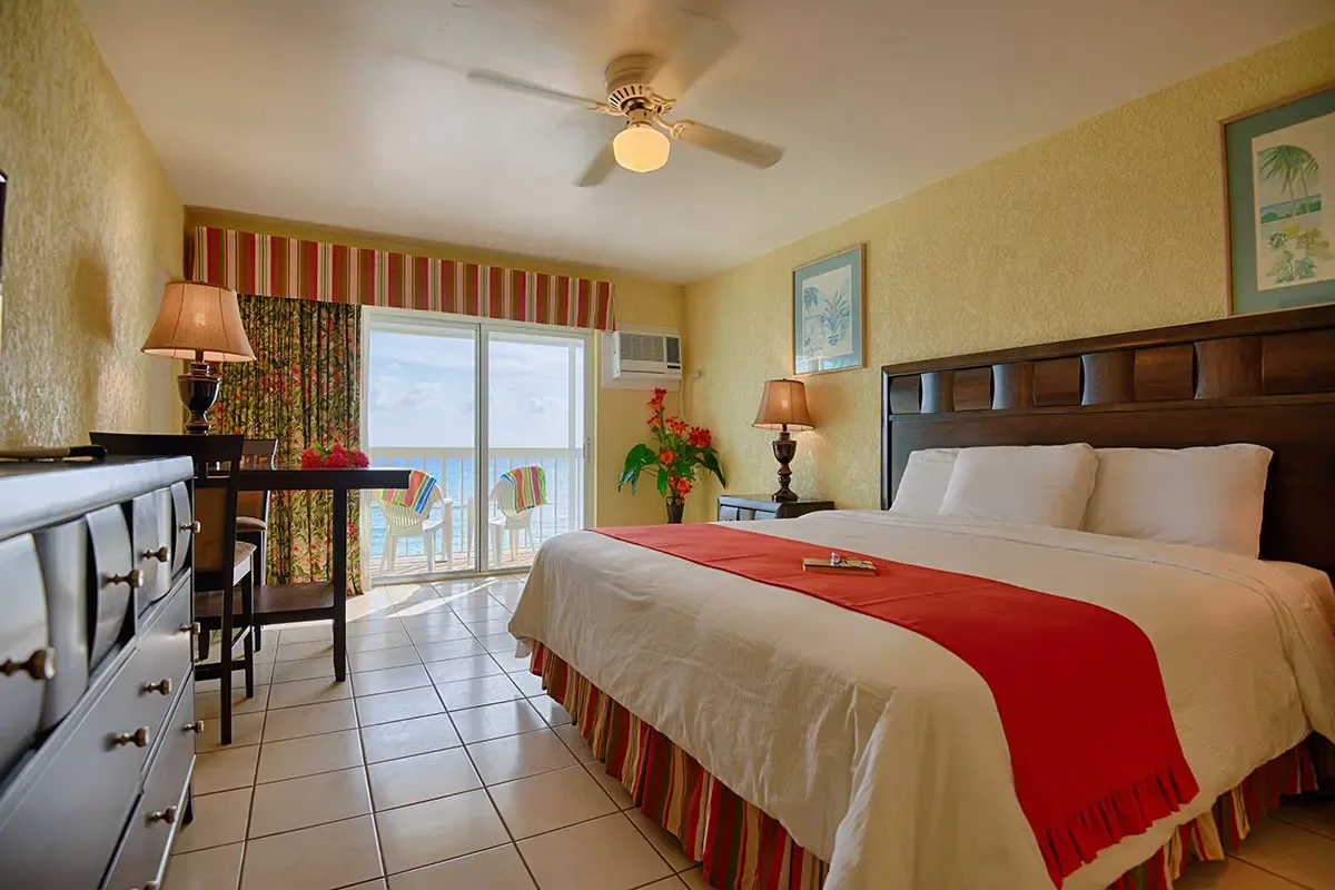 Espacio representativo del hotel: Un dormitorio de hotel con una cama, un escritorio y puertas corredizas de vidrio.