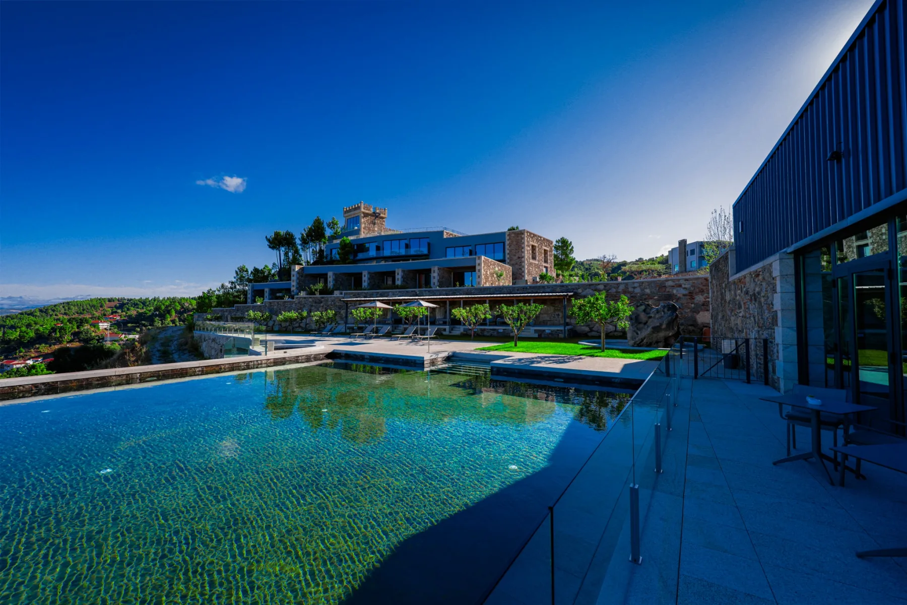 Espacio representativo del hotel: Un moderno complejo hotelero da a una gran piscina al aire libre.