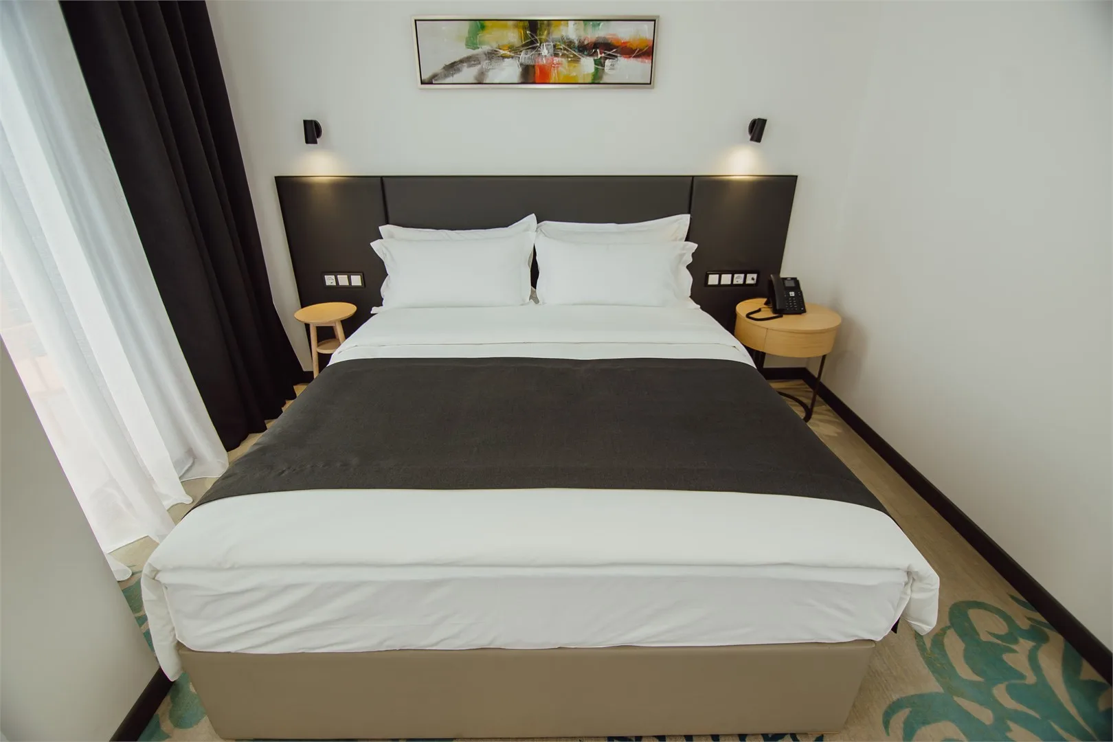 Espacio representativo del hotel: Un dormitorio con una cama bien hecha y mesitas de noche a ambos lados.