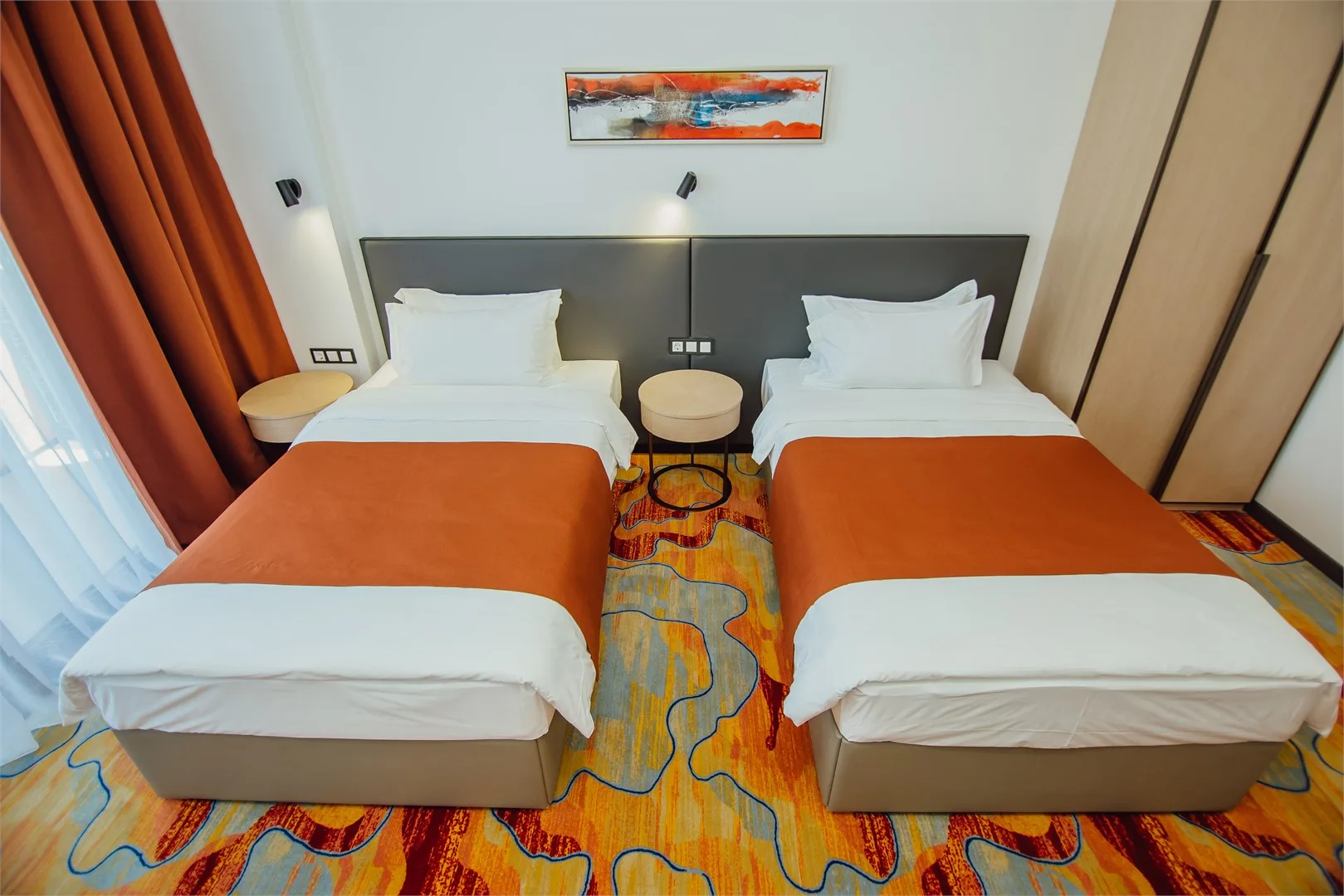 Espacio representativo del hotel: Un dormitorio de hotel con dos camas y una pequeña mesa entre ellas.