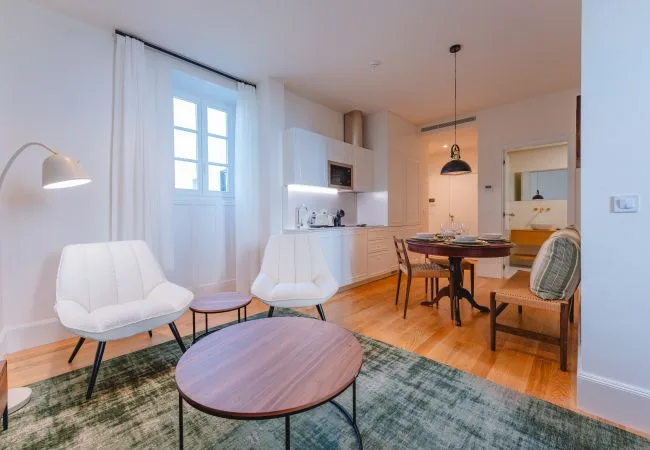 Una luminosa sala-comedor con asientos, una mesa y una cocina compacta.