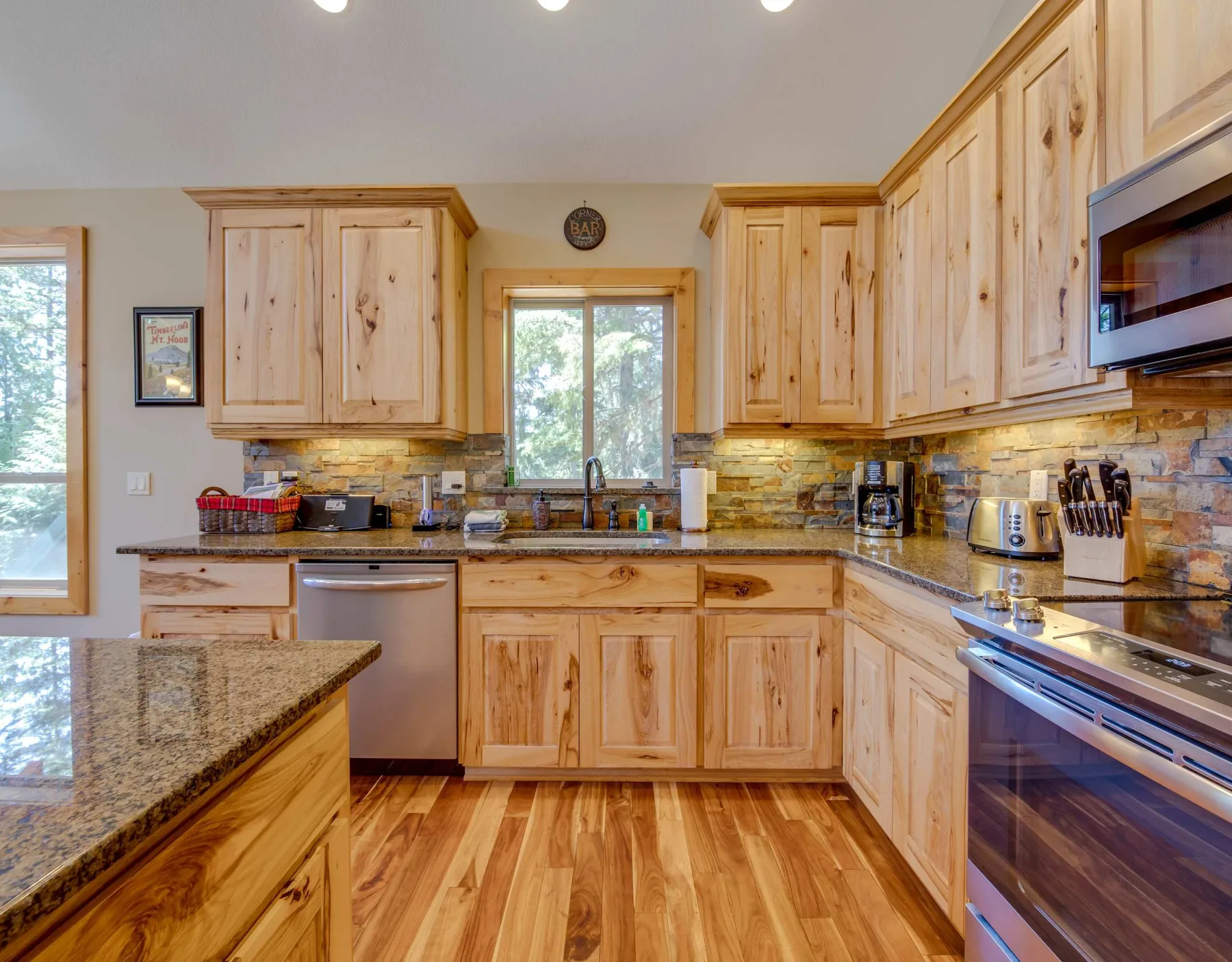 A kitchen with wooden cabinets, countertops, and a central sink.