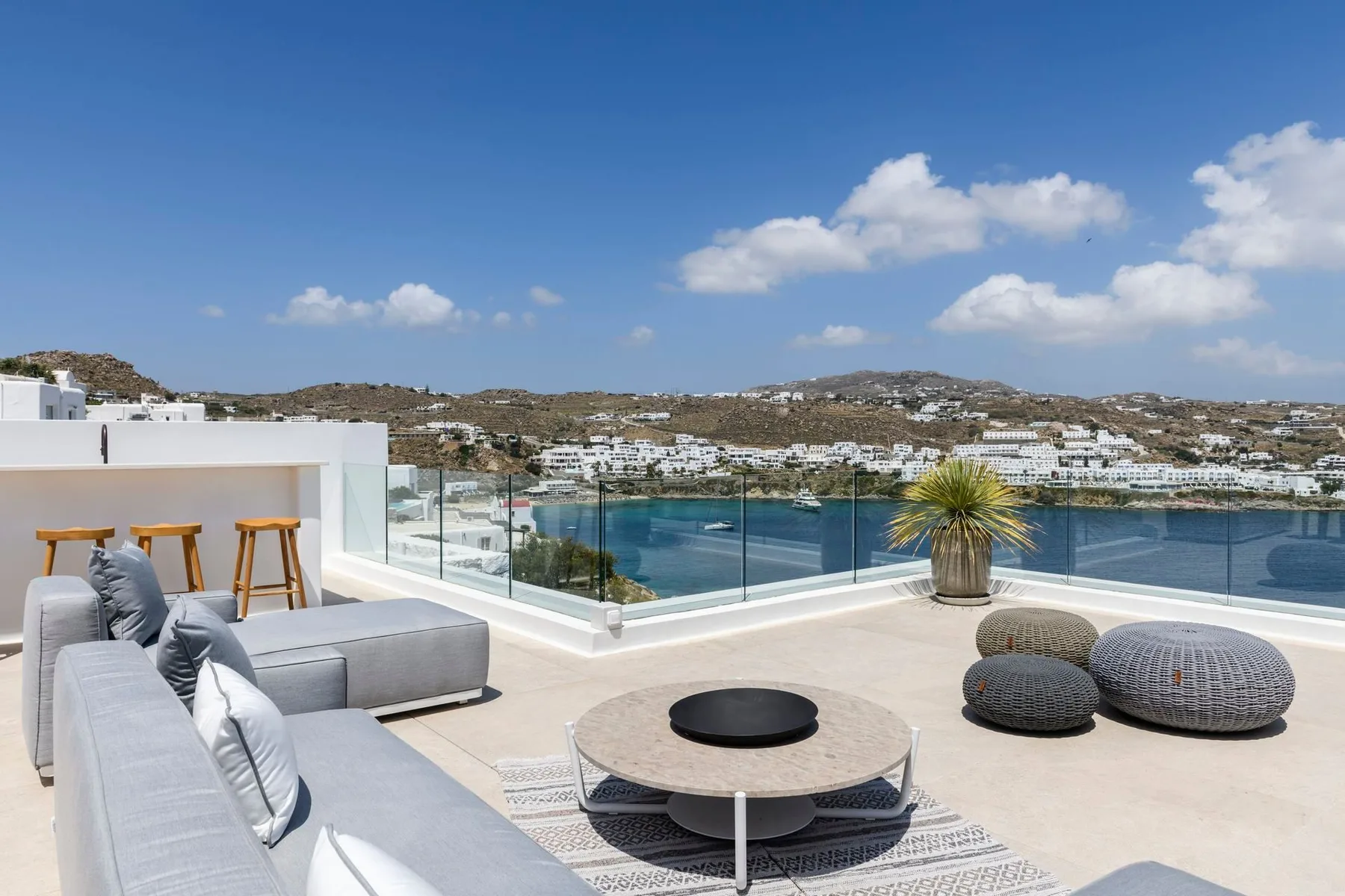 Una terraza en la azotea da al agua, con asientos al aire libre y una mesa baja.
