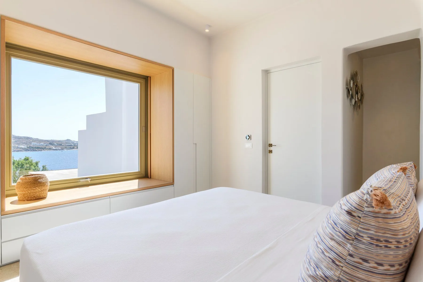 Un dormitorio luminoso con una gran ventana que da al agua.