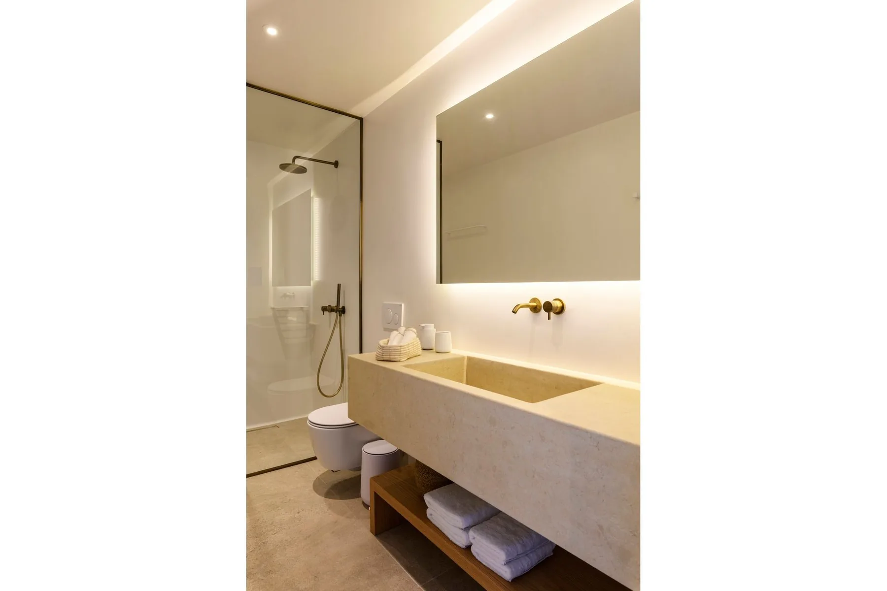 Un baño moderno con un espejo grande, un lavabo y una ducha.