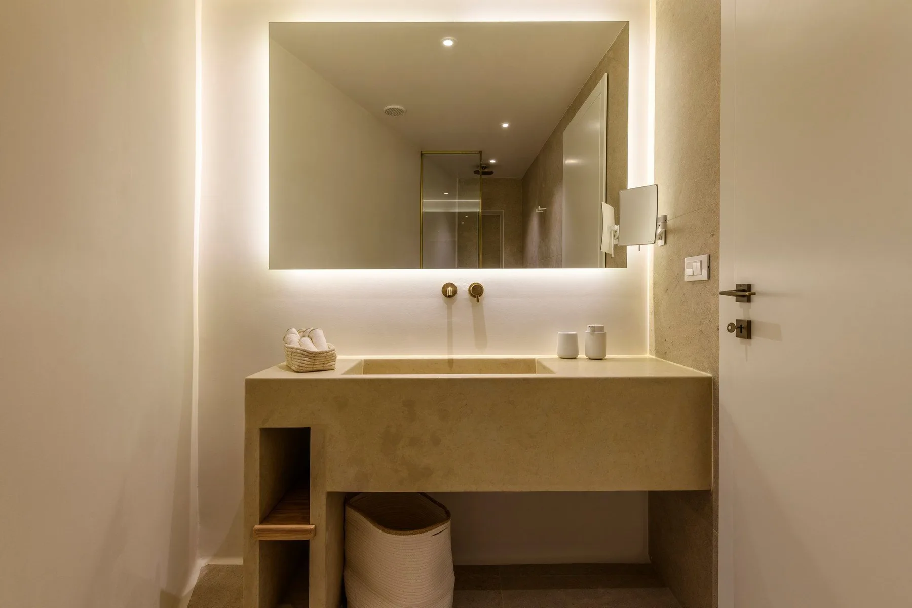 Un tocador de baño con un espejo amplio y un lavabo sobre encimera.