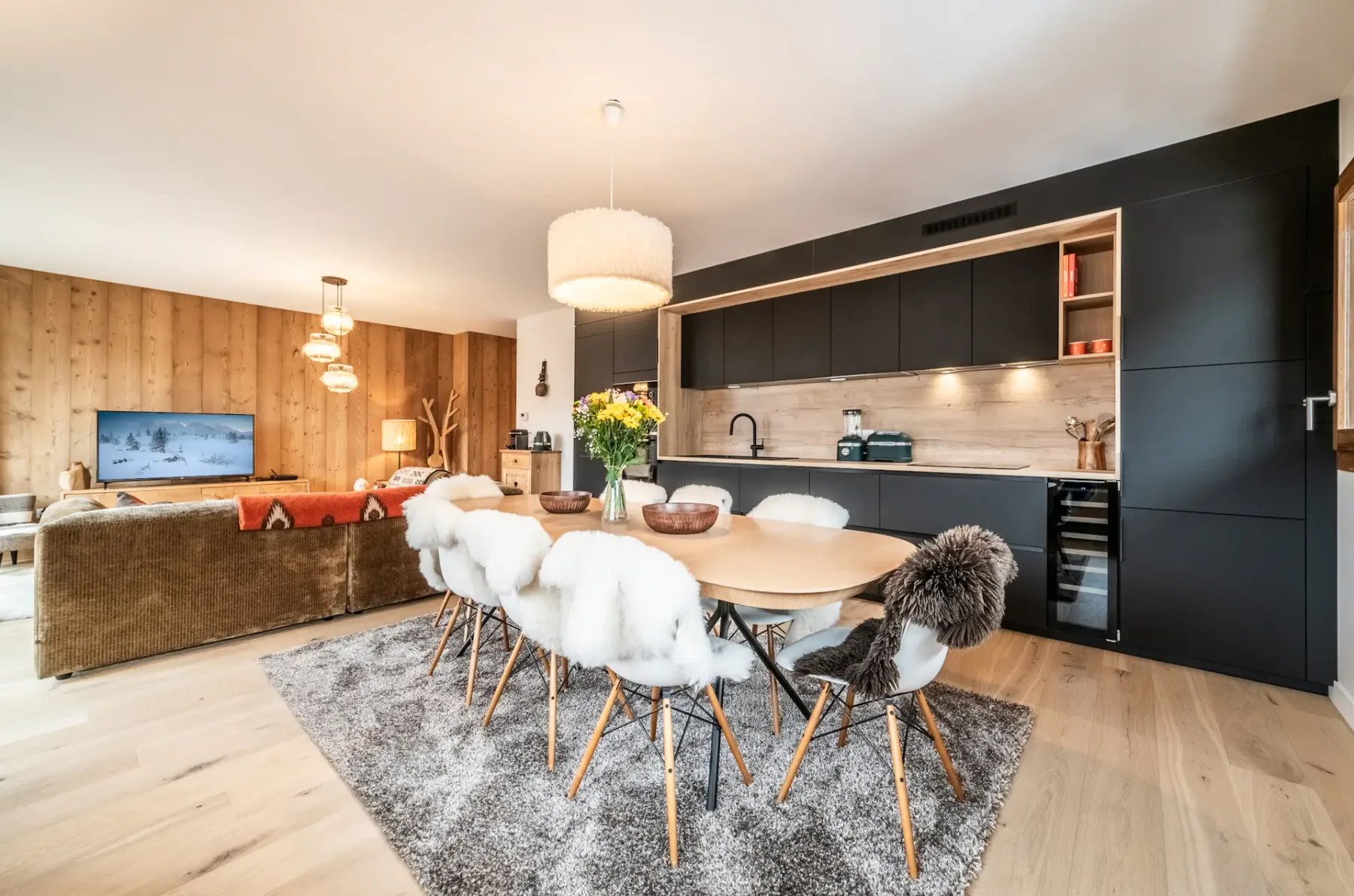 An open-plan living and dining area with a kitchen and a large dining table.