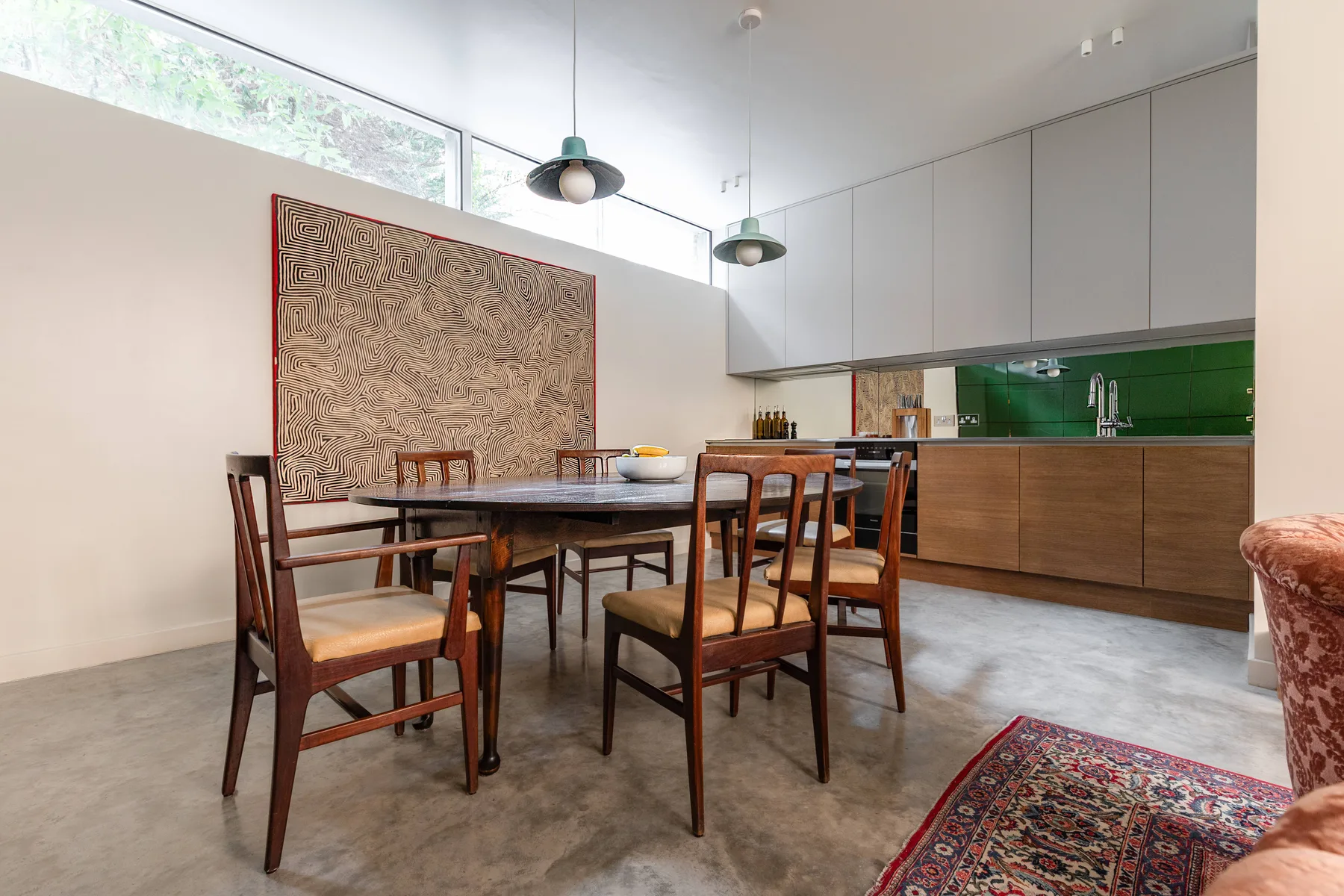 A dining area with a wooden table and chairs beside a kitchen.