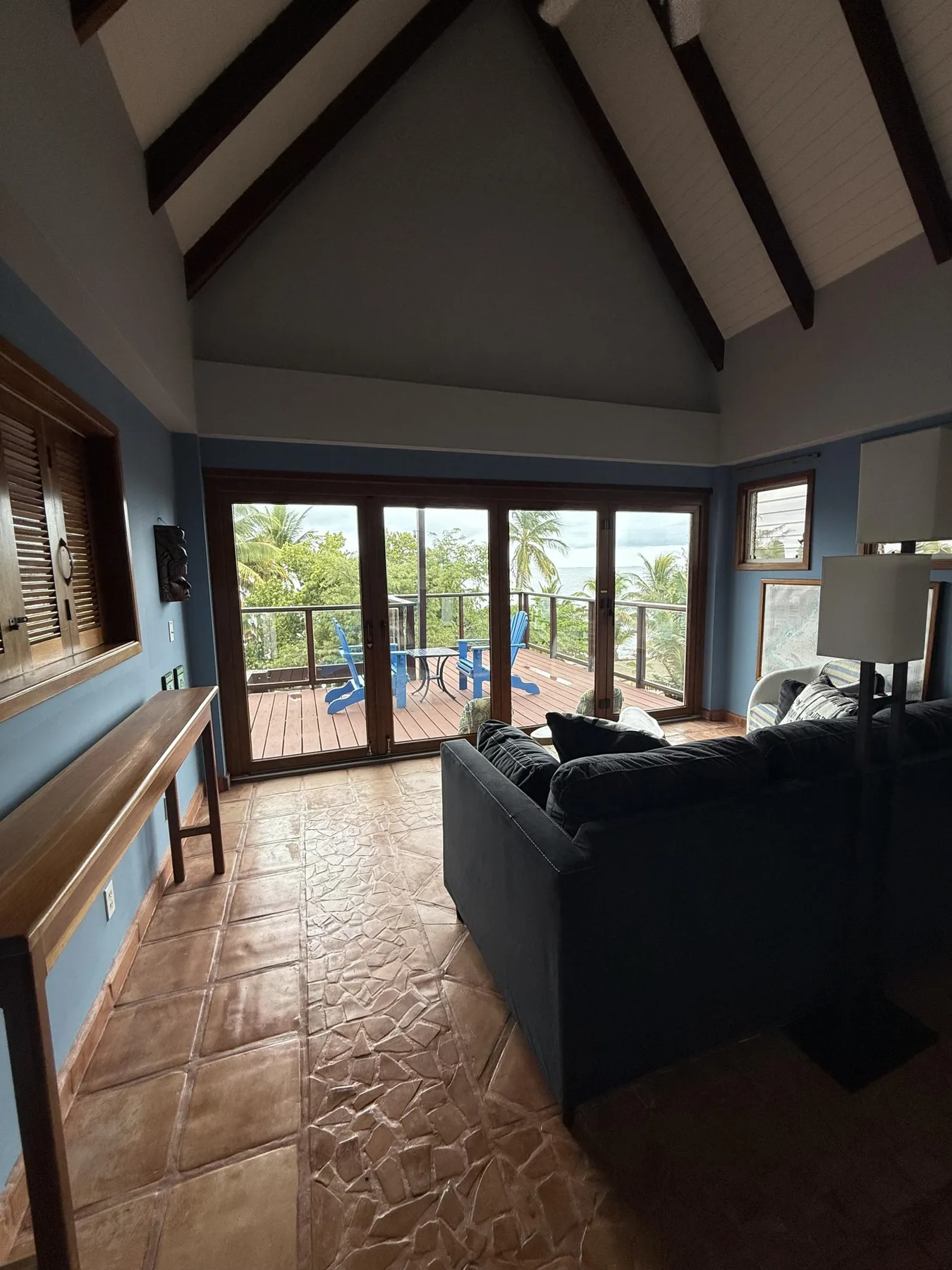 Una sala de estar con asientos y grandes puertas de vidrio que dan a una terraza.