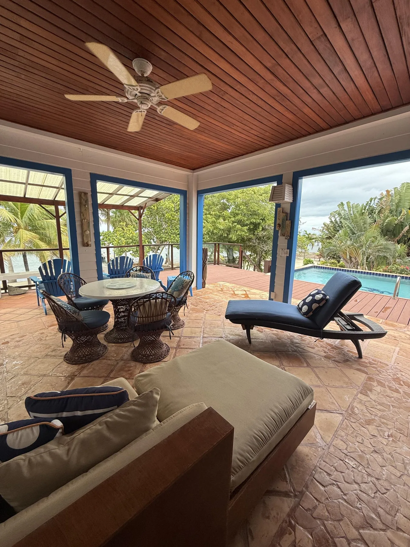 Un patio cubierto con asientos y vistas a la piscina.