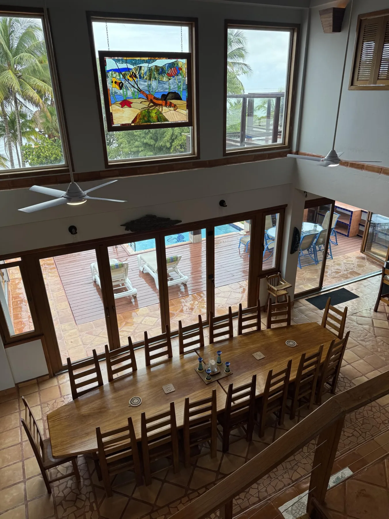Comedor con una mesa larga de madera y ventanales con vistas a una terraza.