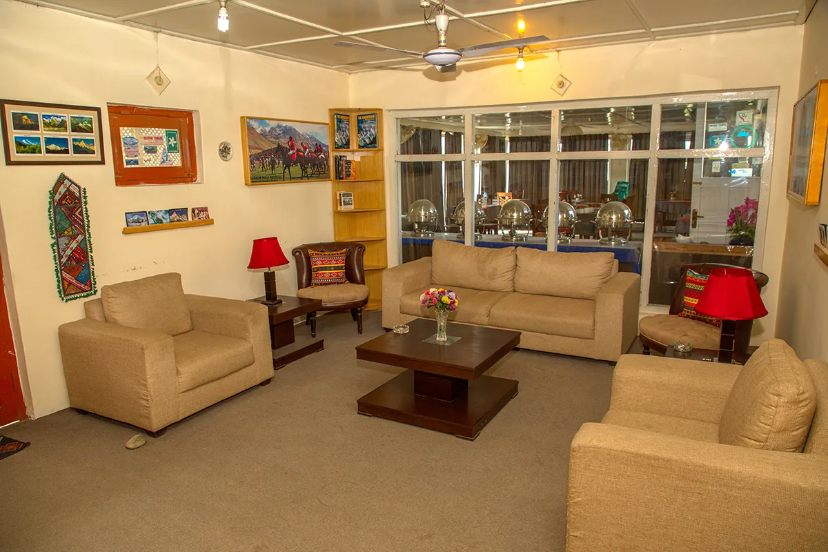Espacio representativo del hotel: Un salón de hotel con asientos beige alrededor de una mesa de centro.