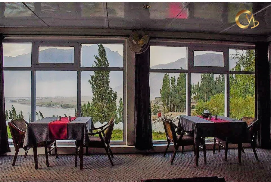 Espacio representativo del hotel: Un comedor con mesas y asientos junto a grandes ventanas con vistas a la vegetación.