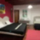 Espacio representativo del hotel: Un dormitorio con una cama y una pared decorativa roja.
