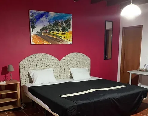 Espacio representativo del hotel: Un dormitorio con una cama doble, cabeceros estampados y arte colorido en la pared.