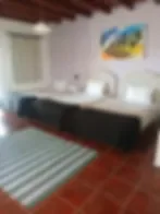 Espacio representativo del hotel: Un dormitorio con una cama y un cuadro colorido de paisaje en la pared.