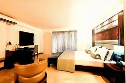 Espacio representativo del hotel: Un dormitorio de hotel con cama, televisor y zona de estar.
