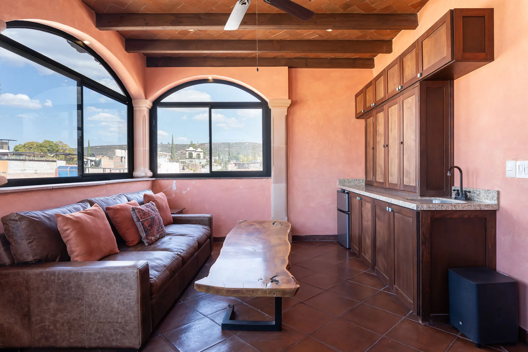A living area with a leather sofa, wooden coffee table, and built-in cabinets.