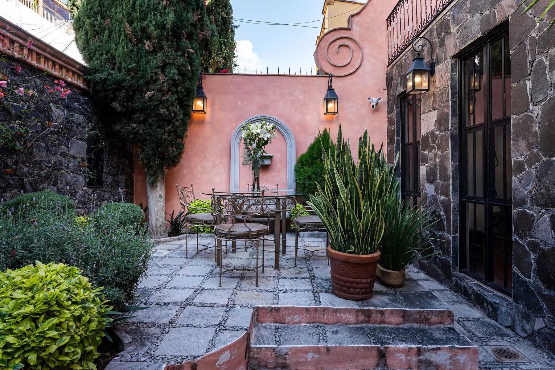 A stone-paved courtyard with outdoor seating and potted plants.