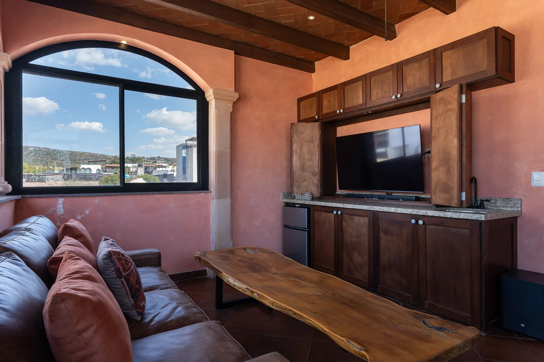 A living room with a couch, wooden coffee table, and television.