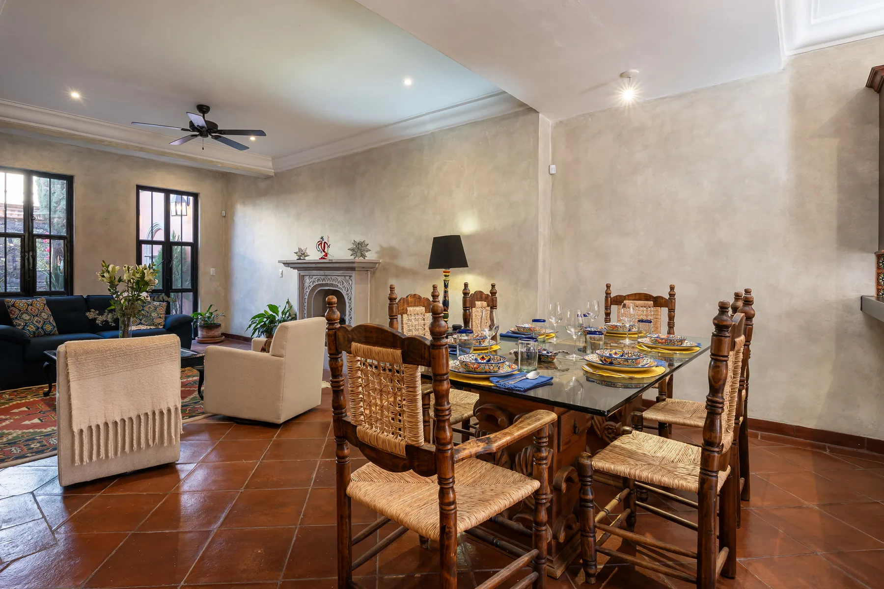A dining area with a wooden table and chairs beside a living room.