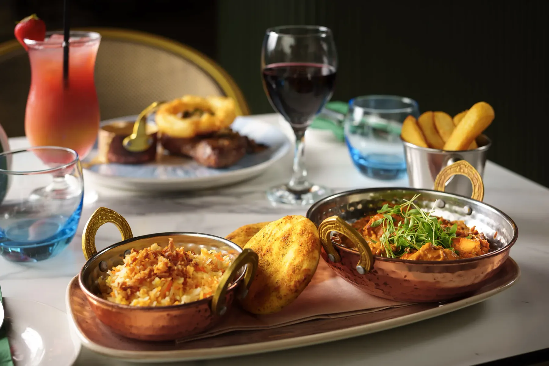 Representative hotel space: A restaurant table displays several prepared dishes, bread, drinks, and a dessert.