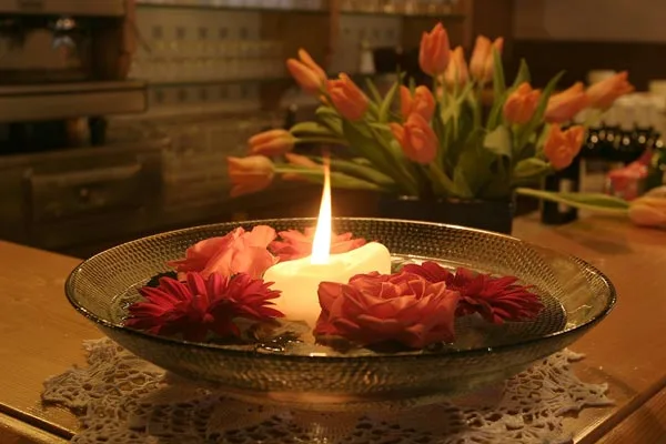 Representative hotel space: A candle and flowers sit on a dining table in a warmly lit room.