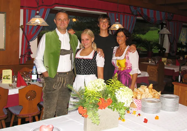 Representative hotel space: Four people pose behind a buffet table with flowers and stacks of plates.