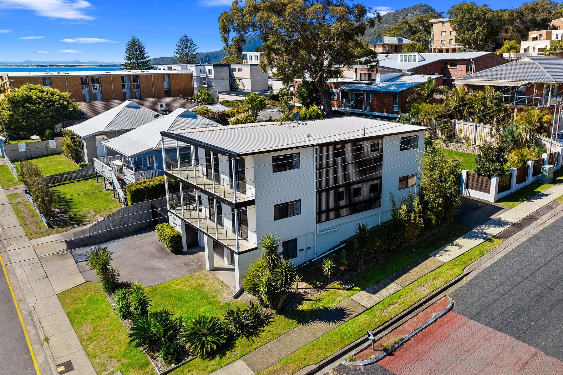 Vista aérea de un edificio moderno de dos plantas junto a una calle residencial.