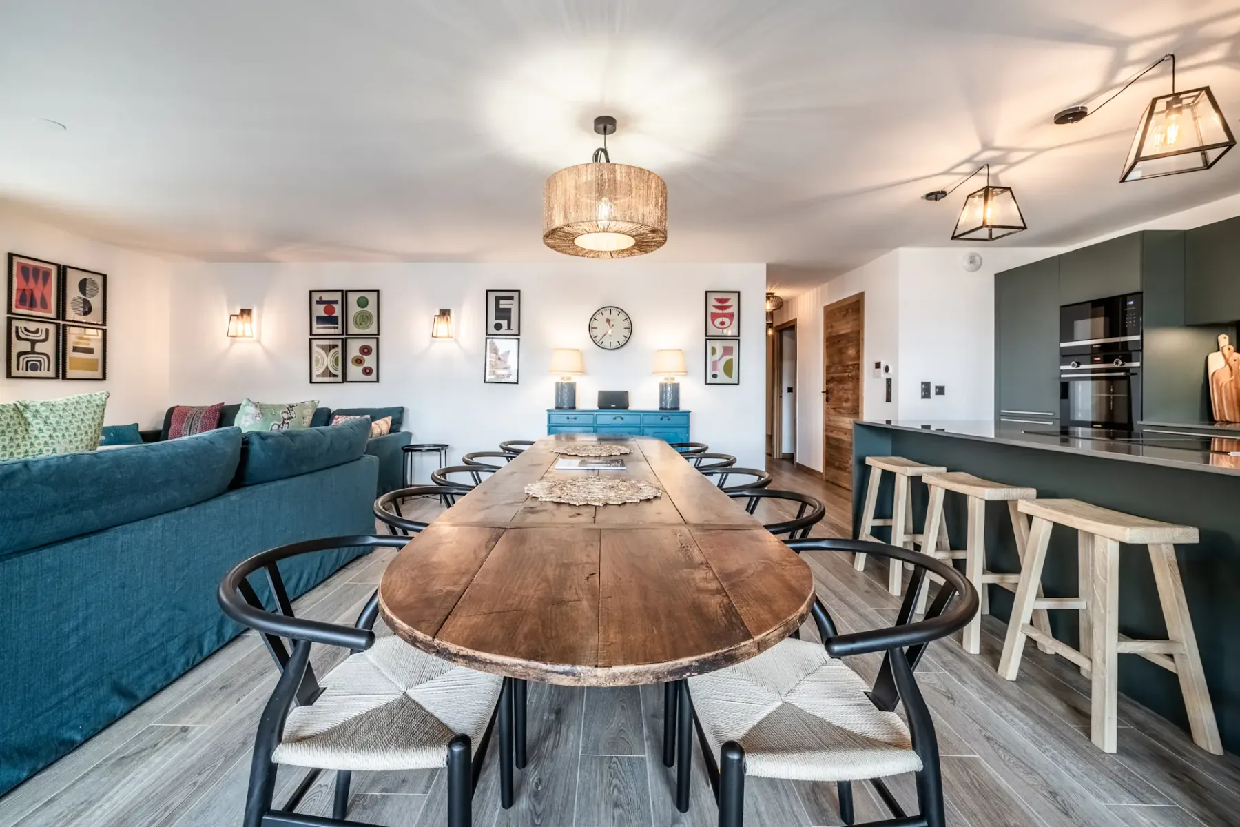 Una mesa de comedor con sillas está junto a una sala de estar y una cocina.