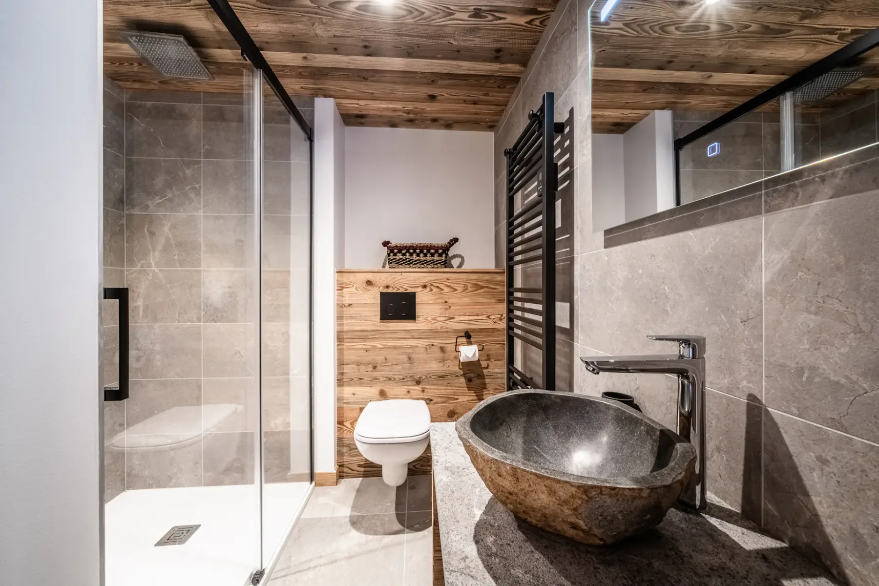 Un baño moderno con ducha de vidrio y un lavabo independiente.