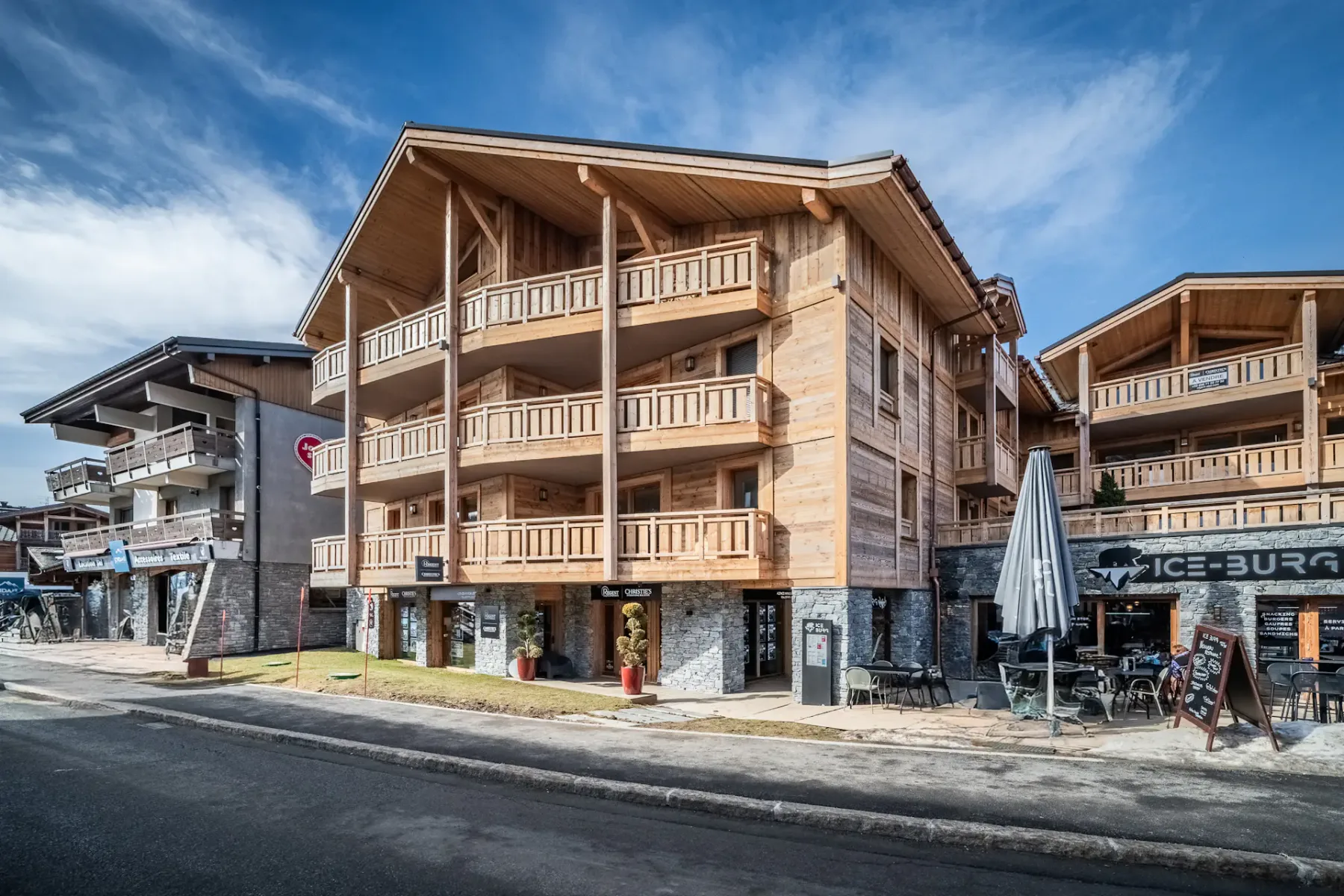 Zona común: Un edificio revestido de madera se alza junto a una calle.