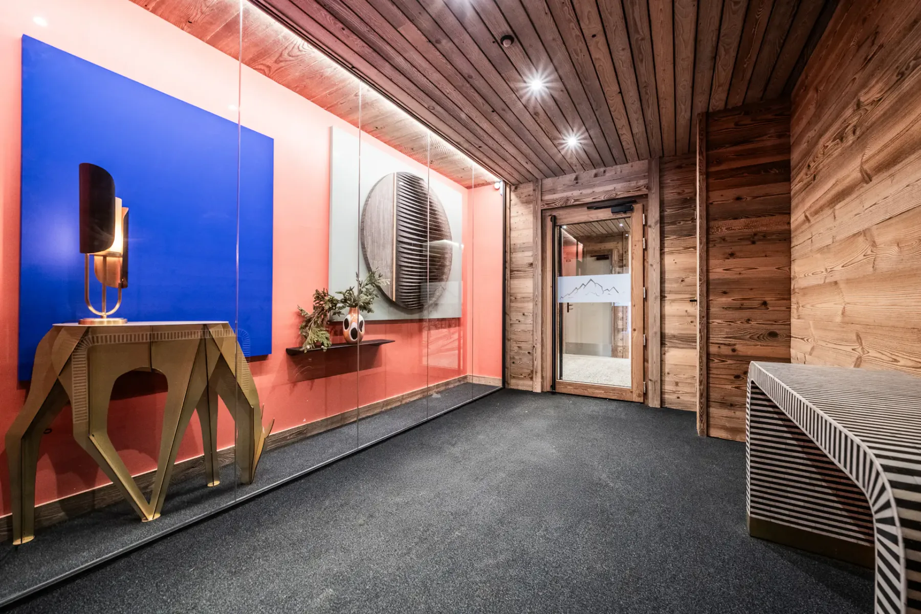Zona común: Un pasillo moderno con una exhibición de arte colorida y una puerta.