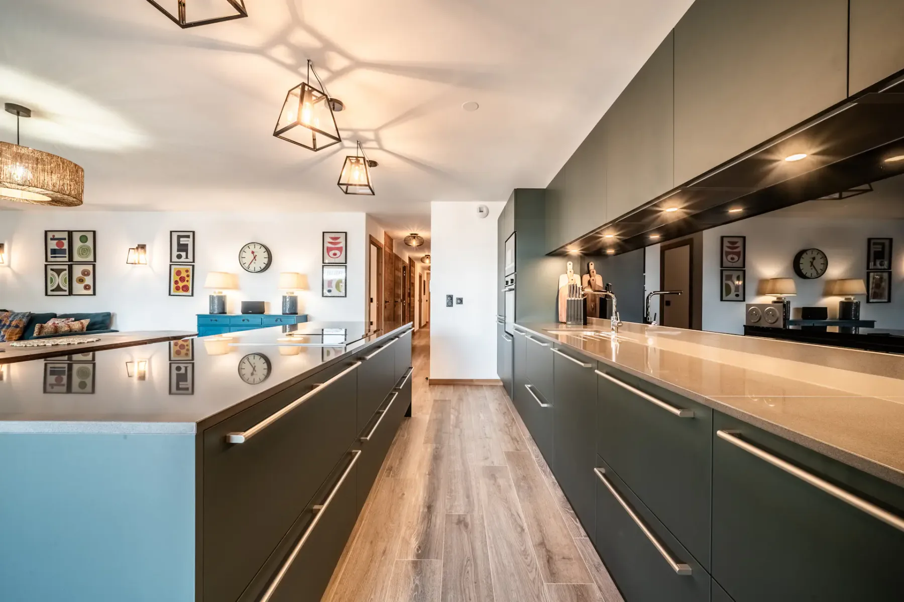 Una cocina moderna con gabinetes oscuros, encimeras claras y una isla central.