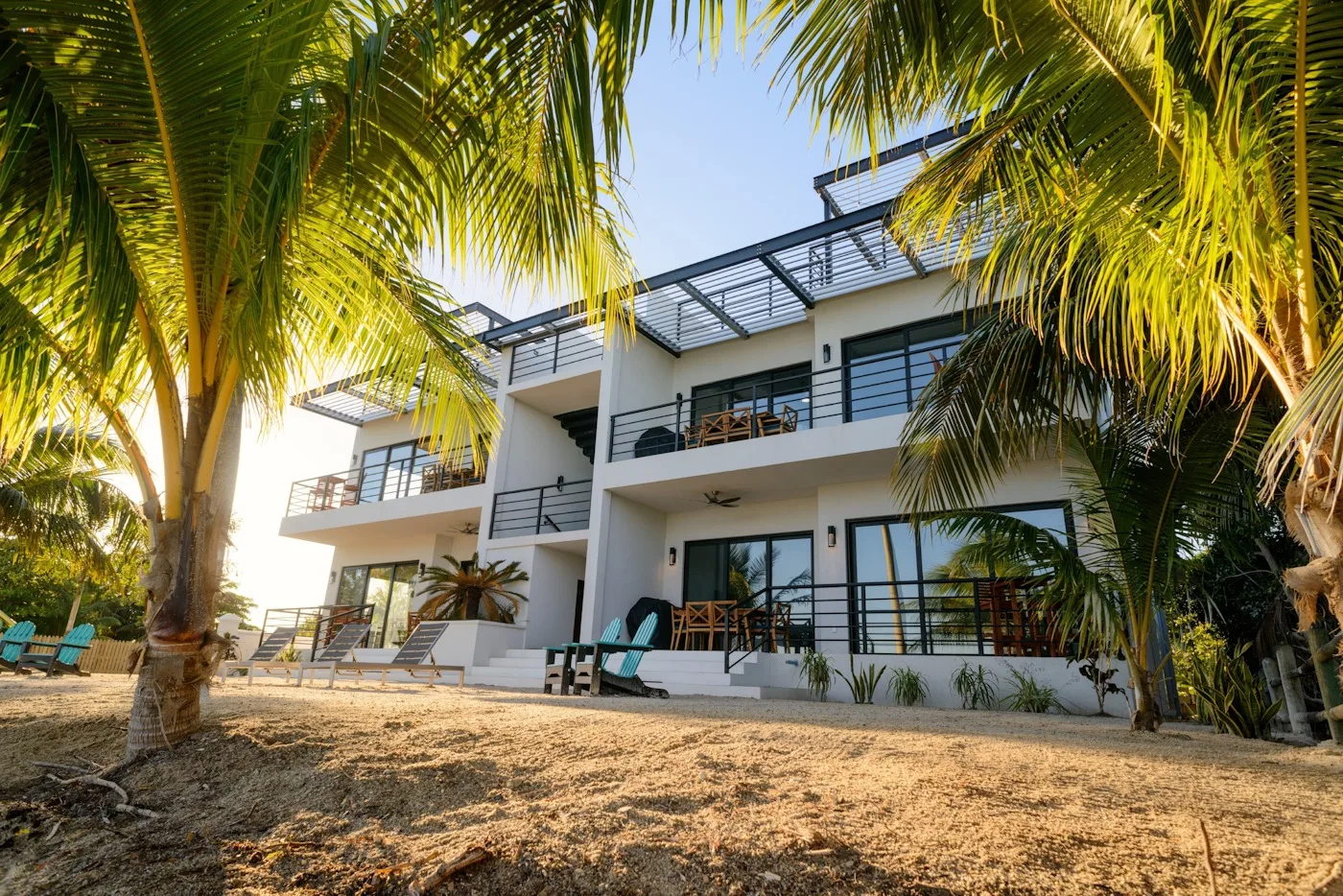 Zona común: Un edificio moderno de varios pisos con balcones está rodeado de palmeras.