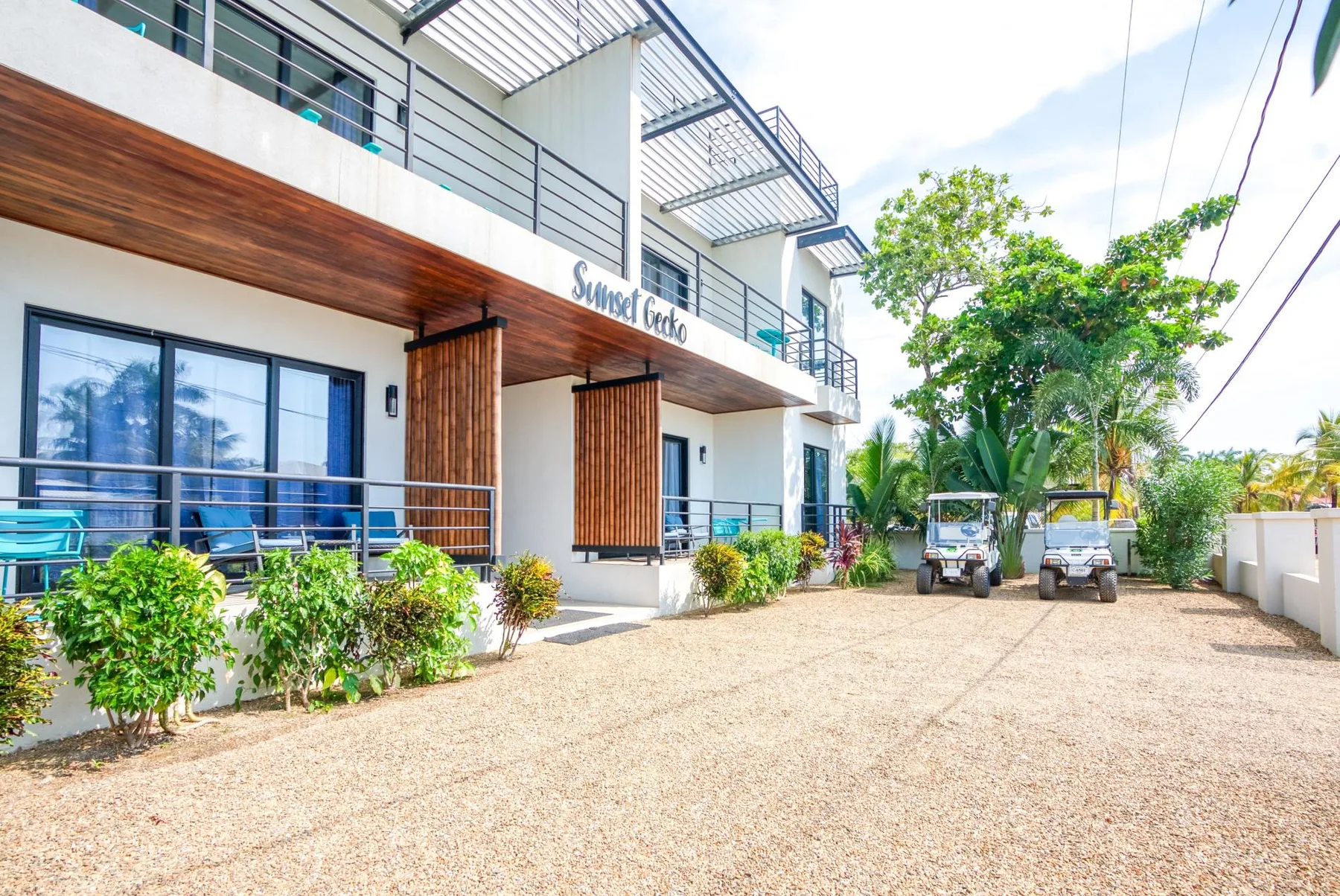 Shared amenity: A modern building with balconies opens onto a gravel driveway.