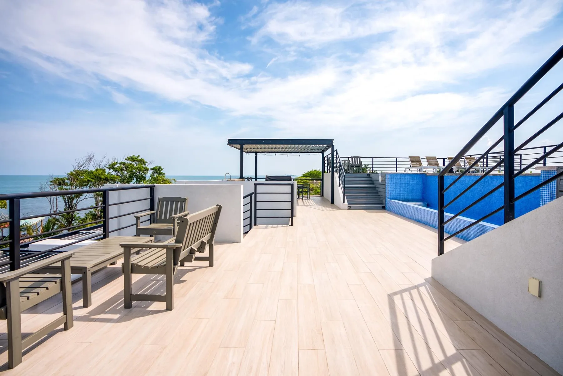 Zona común: Una terraza al aire libre con asientos y una piscina azul.