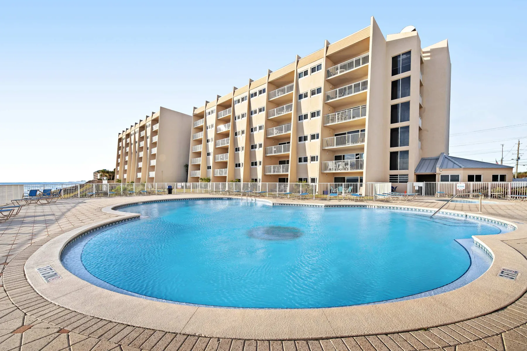Zona común: Piscina al aire libre frente a un edificio de varios pisos.