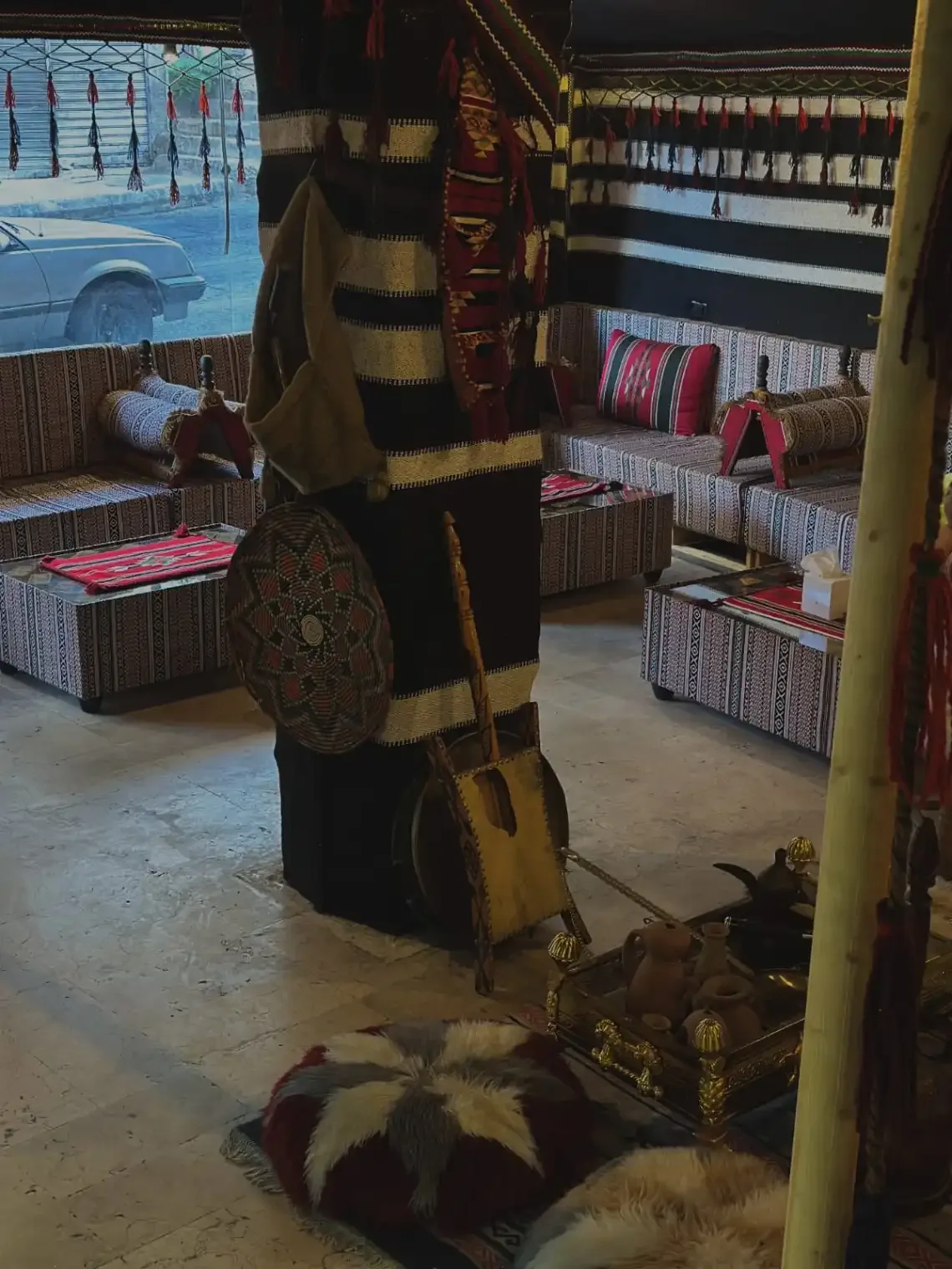 Espacio representativo del hotel: Una zona de asientos de estilo tradicional con cojines a rayas y alfombras.