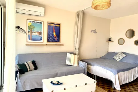 Un dormitorio con una cama, un diván y una mesa de centro blanca.