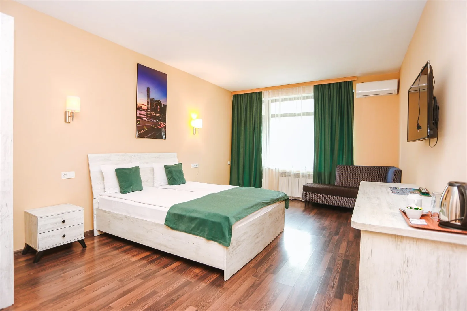 Espacio representativo del hotel: Un dormitorio con una cama, cortinas verdes y una pequeña zona de estar.