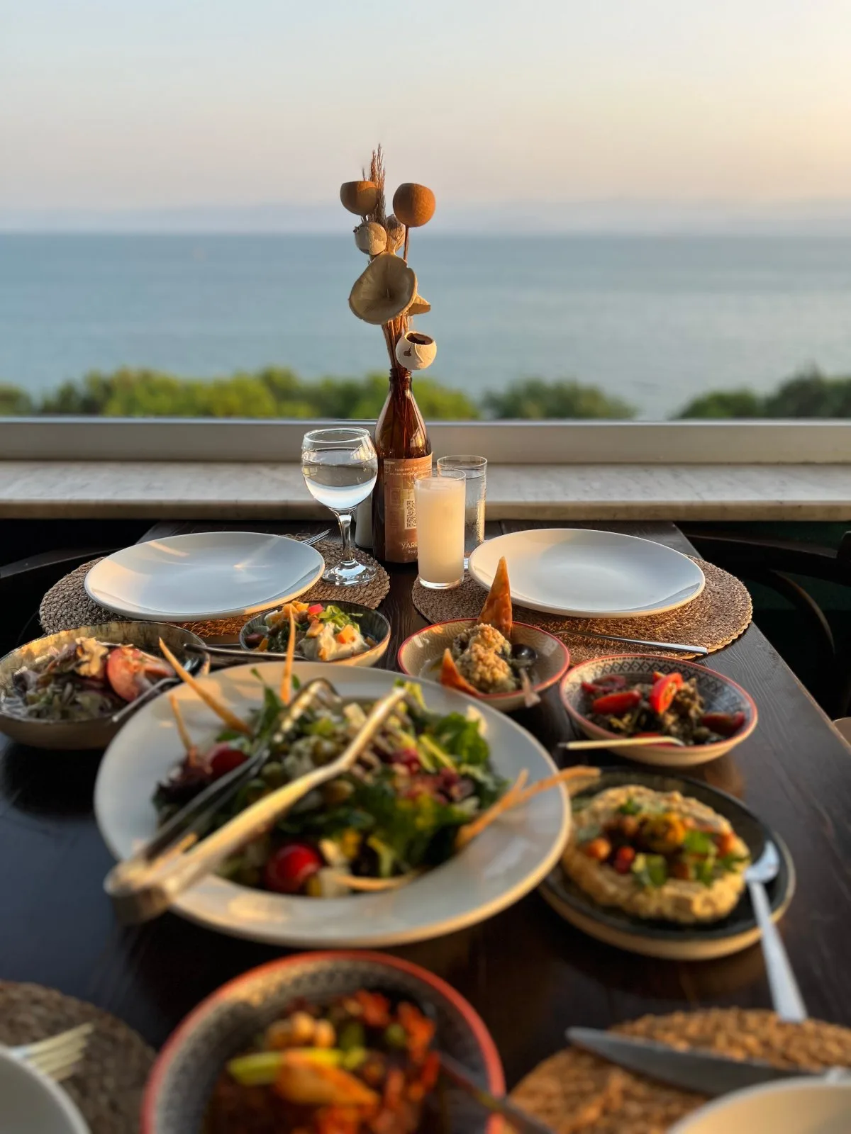 Espacio representativo del hotel: Una mesa puesta con platos y varios platillos tiene vistas al mar.