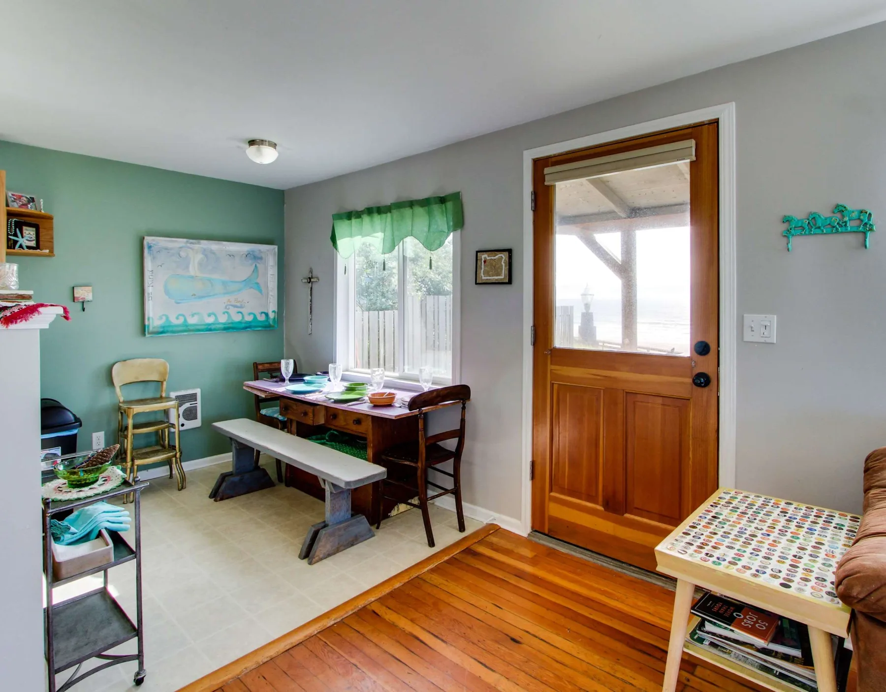 A dining area with a wooden table beside a window and glazed exterior door.