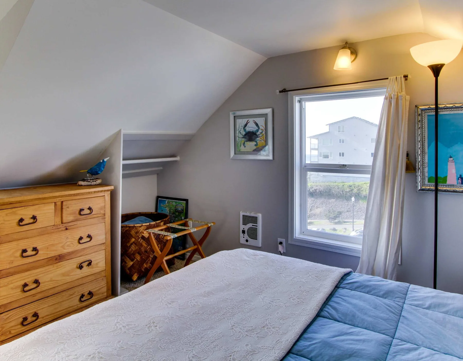 A bedroom with a bed beneath a sloped ceiling and a window.