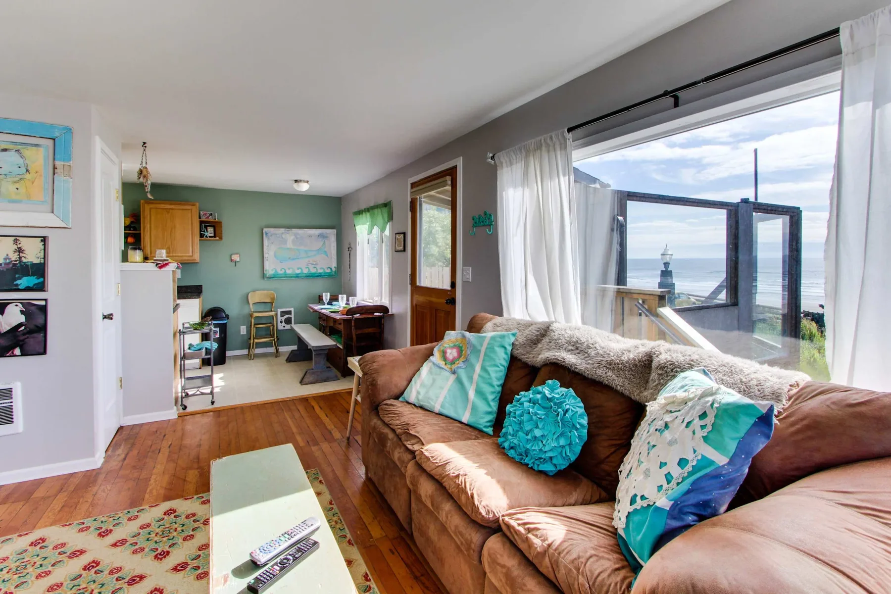 A living room with a sofa and large windows overlooking the water.