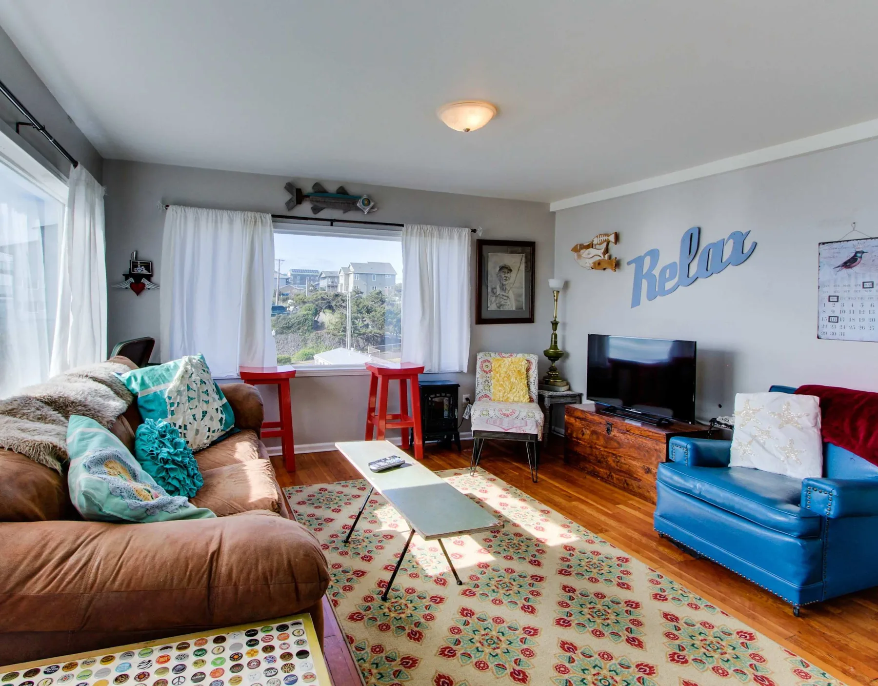 A living room with seating, a television, and a patterned rug.
