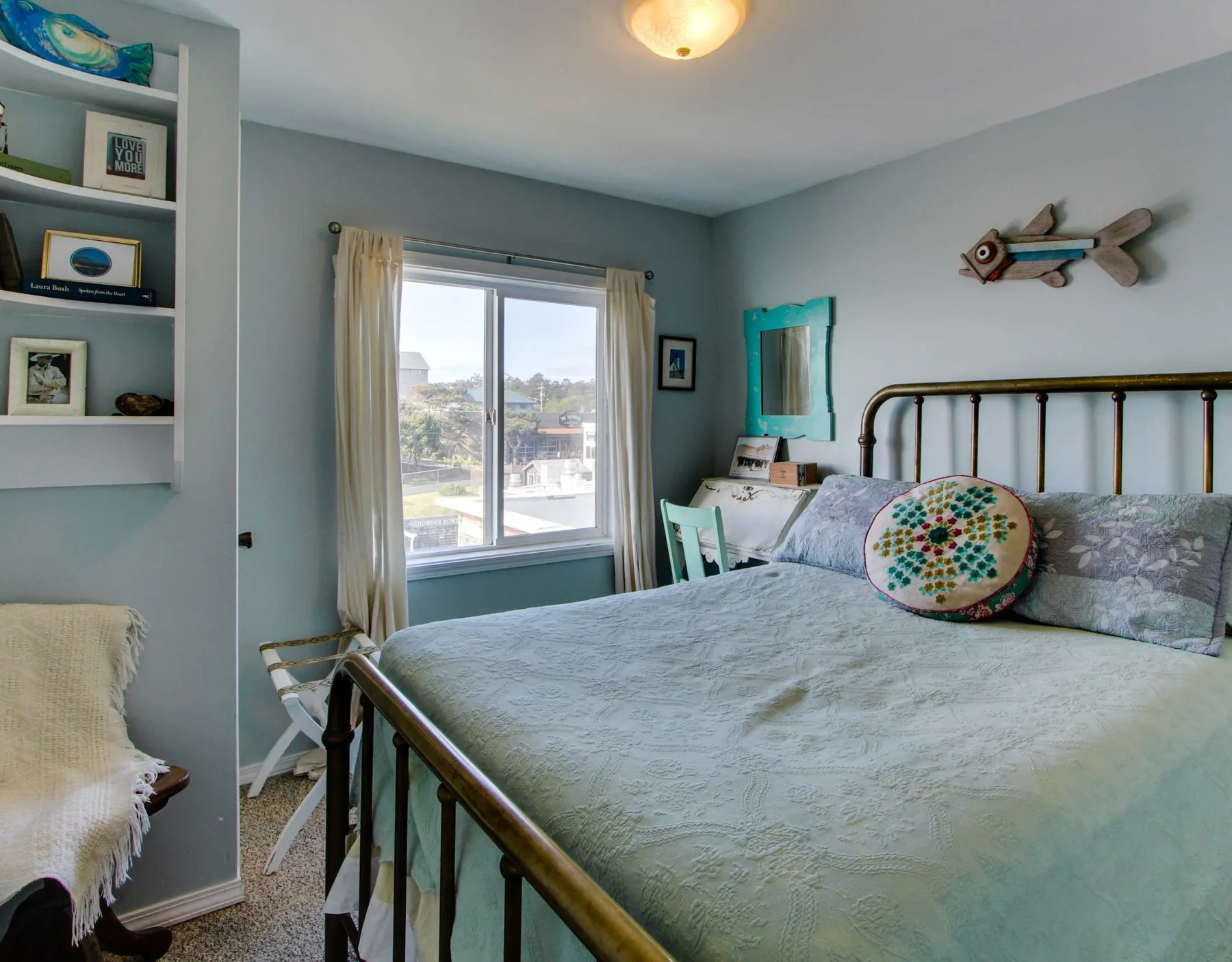 A bedroom with a bed, a window, and built-in shelving.