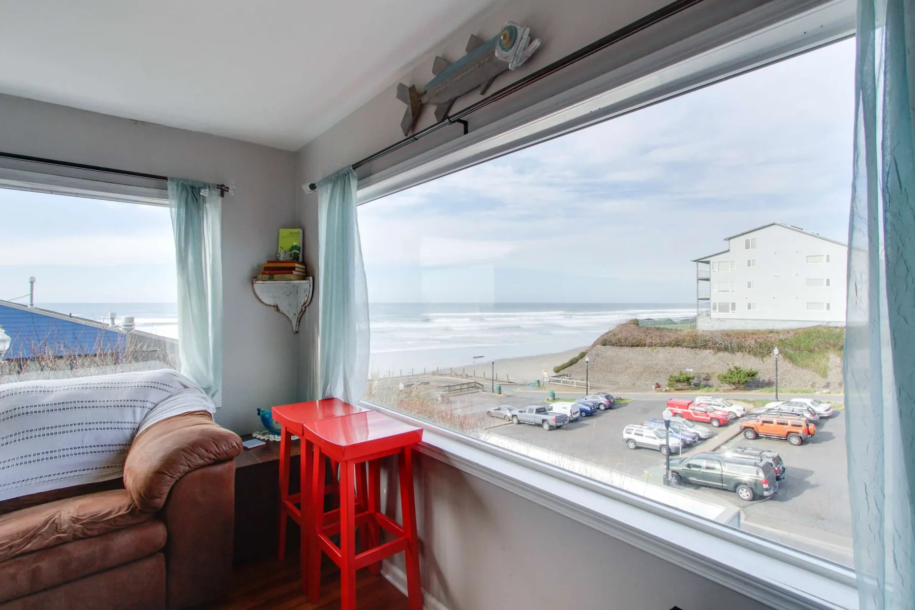 A bright room with large windows overlooking the beach and ocean.