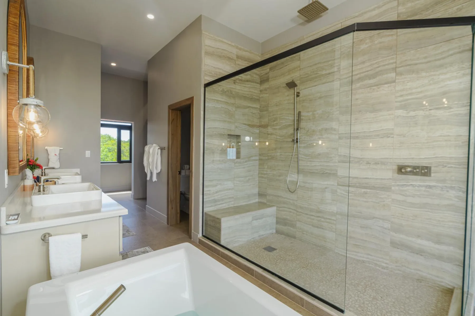 A modern bathroom with a glass-enclosed shower and a bathtub.